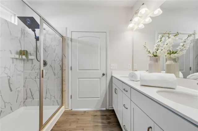 a spacious bathroom with a granite countertop sink a mirror and a shower