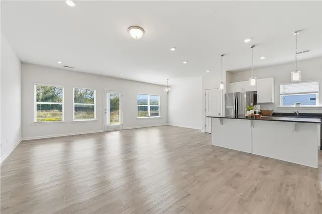 a view of kitchen with stainless steel appliances refrigerator sink and cabinets