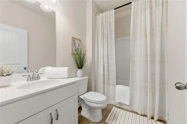 a bathroom with a sink a toilet and shower curtain