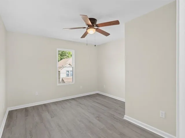 an empty room with a window and a ceiling fan