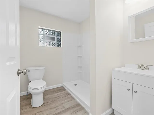 a bathroom with a toilet a sink and mirror