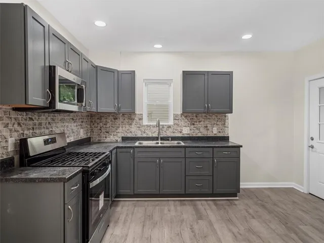 a kitchen with stainless steel appliances granite countertop wooden cabinets and a stove top oven