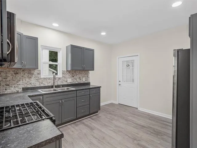 a kitchen with stainless steel appliances granite countertop a sink stove and refrigerator