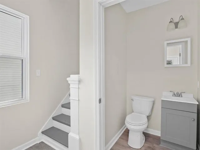 a white toilet sitting next to a bathroom sink and vanity