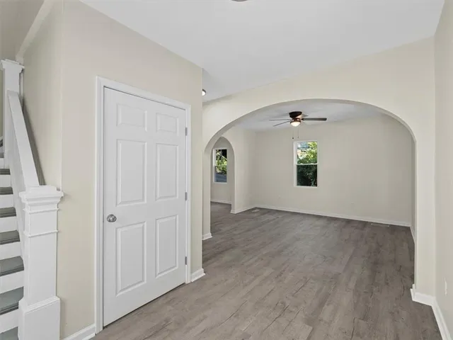 an empty room with wooden floor and mirror