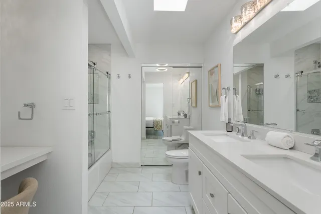 a bathroom with a double vanity sink toilet and shower