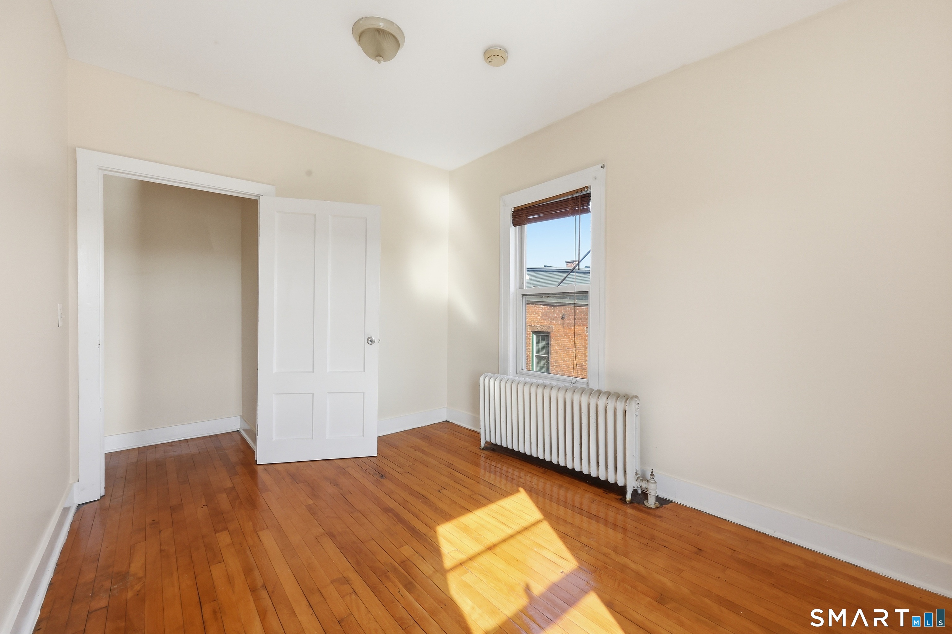 360 Main Street, Unit 3B Middletown, CT 06457 - Photo 10 of 21 a bedroom with a bed and wooden floor