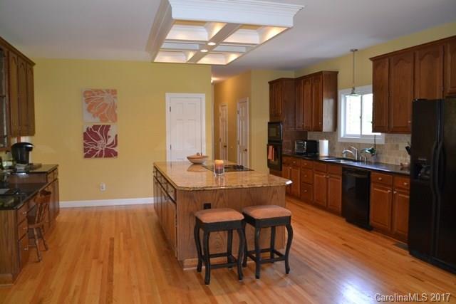 483 Beacon Knoll Lane Fort Mill, SC 29708 - Photo 6 of 21 a kitchen with granite countertop wooden floors and wooden cabinets