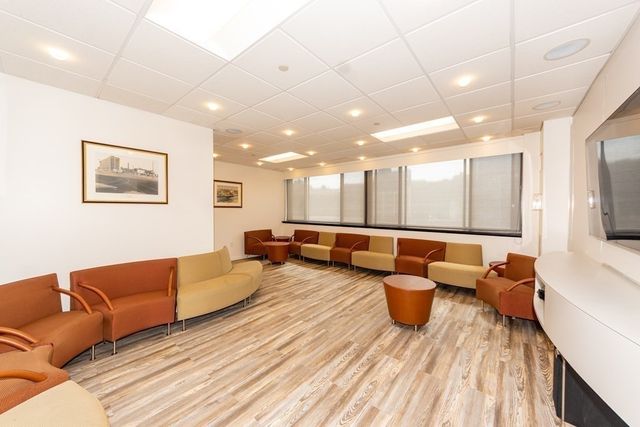 a living room with couches and kitchen view with wooden floor