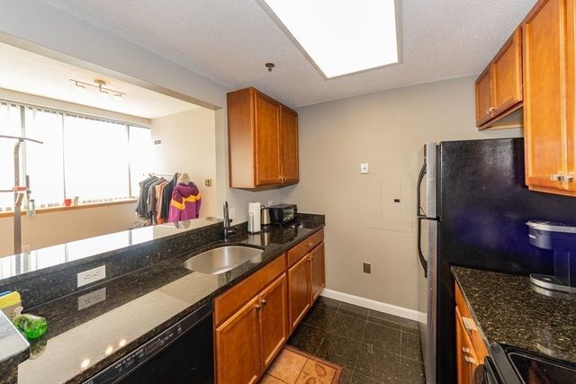 a kitchen with granite countertop a sink and a refrigerator