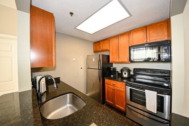 a kitchen with stainless steel appliances granite countertop a stove a sink and a refrigerator