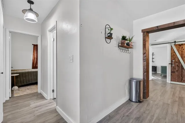 a view of a hallway with wooden floor and closet