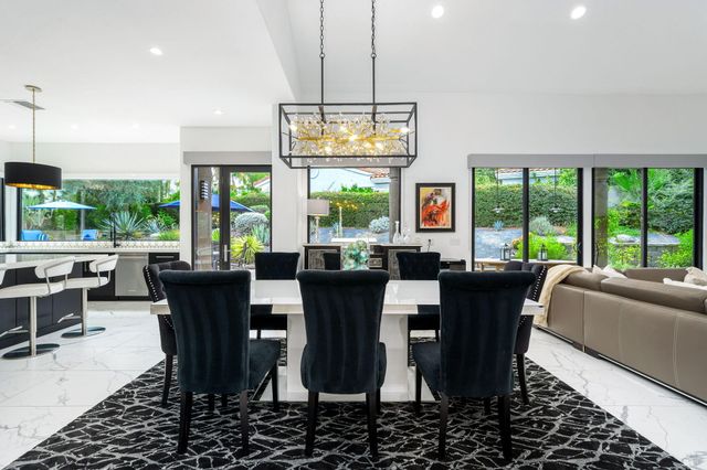 a dining room with furniture a chandelier and window