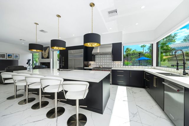 a kitchen with stainless steel appliances kitchen island granite countertop a sink and cabinets