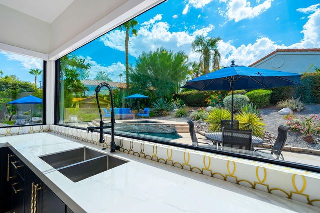 a view of a patio with a table and chairs under an umbrella