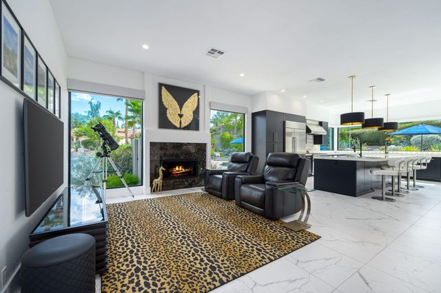 a living room with furniture a large window and a fireplace