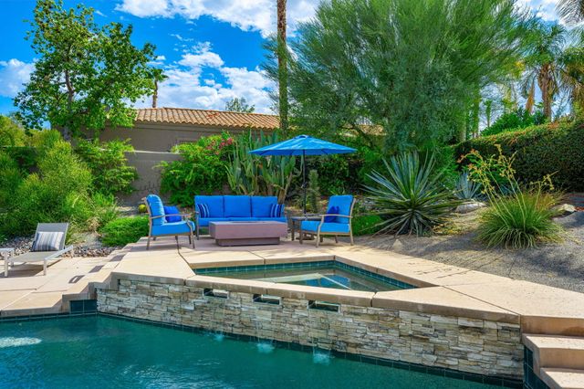 a view of a house with backyard sitting area and swimming pool