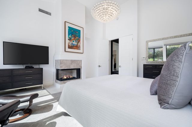 a spacious bedroom with a bed and a flat screen tv