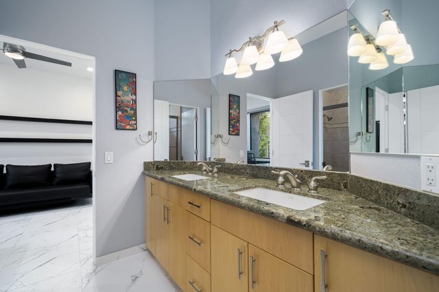a bathroom with a granite countertop double vanity sink and a mirror
