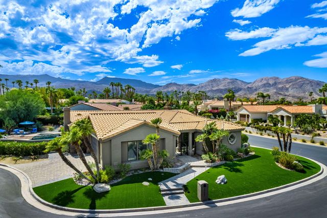 a view of a swimming pool with lawn chairs and plants