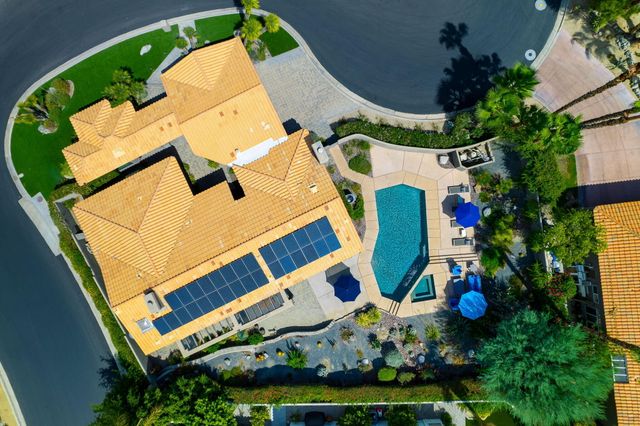 an aerial view of a house with swimming pool and outdoor seating