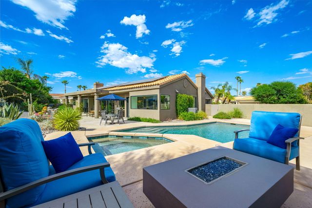 a view of an house with backyard and sitting area