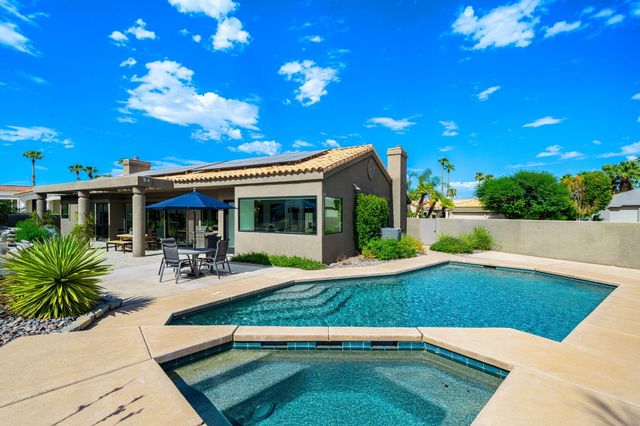 a view of a house with backyard porch and sitting area