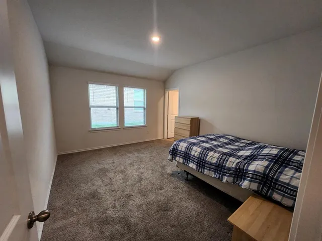 a bed sitting in a bedroom next to a window