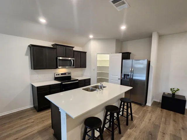 a kitchen that has a table chairs and refrigerator