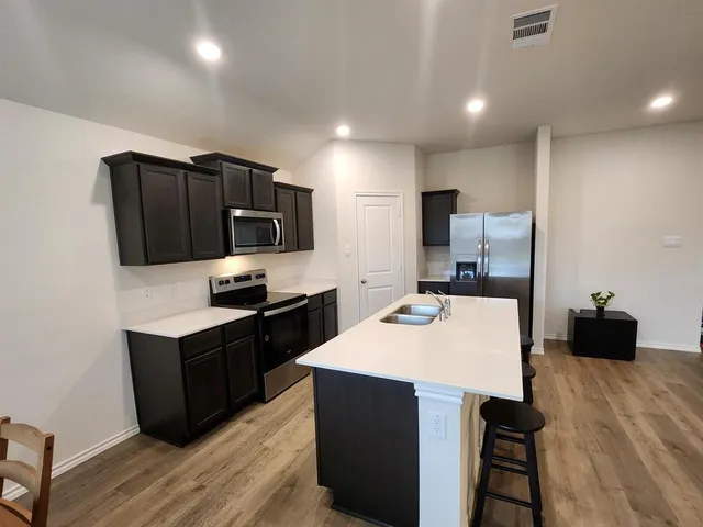 a kitchen with a sink a counter top space and stainless steel appliances