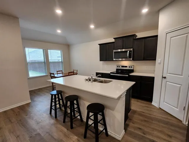 a kitchen with a table chairs refrigerator and microwave