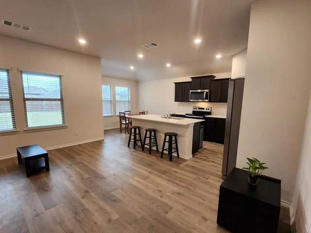 a kitchen with stainless steel appliances a refrigerator and a stove top oven