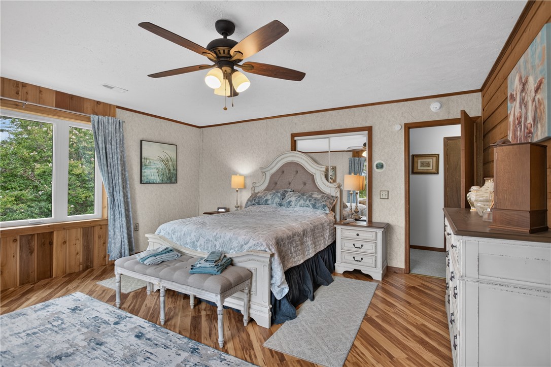 351 River Road Westminster, SC 29693 - Photo 22 of 50 Natural wood flooring complements the window views of lush greenery in this inviting primary sleeping space.