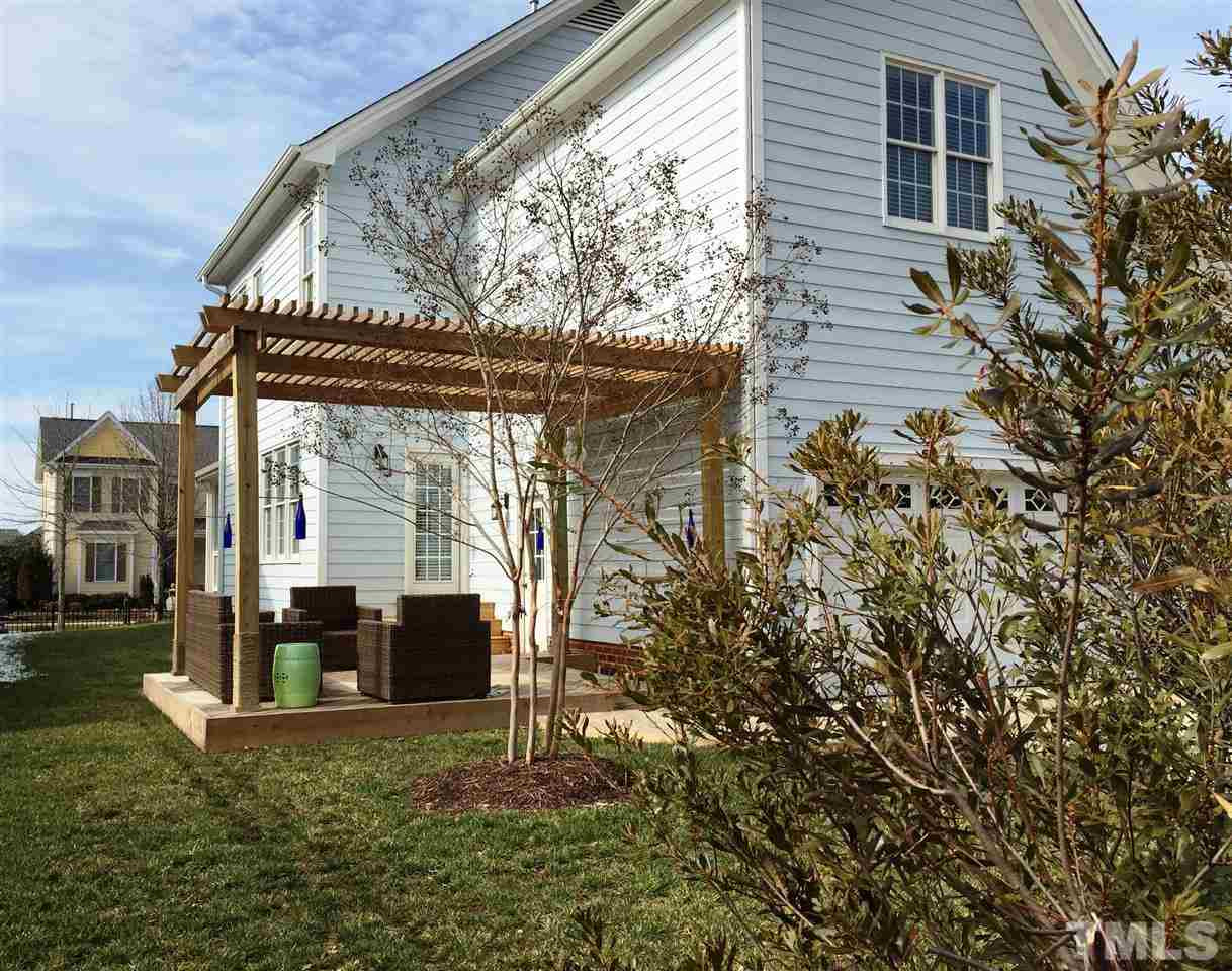 1307 Ileagnes Road Raleigh, NC 27603 - Photo 3 of 24 The rear facing garage is accessed from an HOA maintained service road. The grassy side yard is a great place for pets or to throw a ball and the deck and pergola have easy access from the kitchen or the garage. Back of House