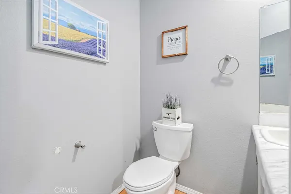 a white toilet sitting next to a bathroom sink and vanity