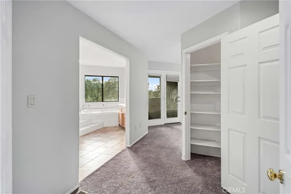 an empty room with windows and chandelier fan