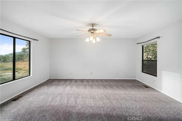 an empty room with closet and a ceiling fan