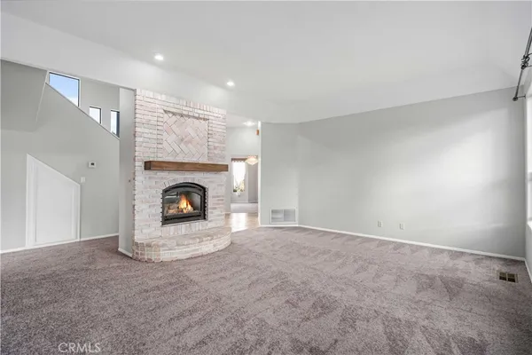 a view of an empty room with a fireplace and a window