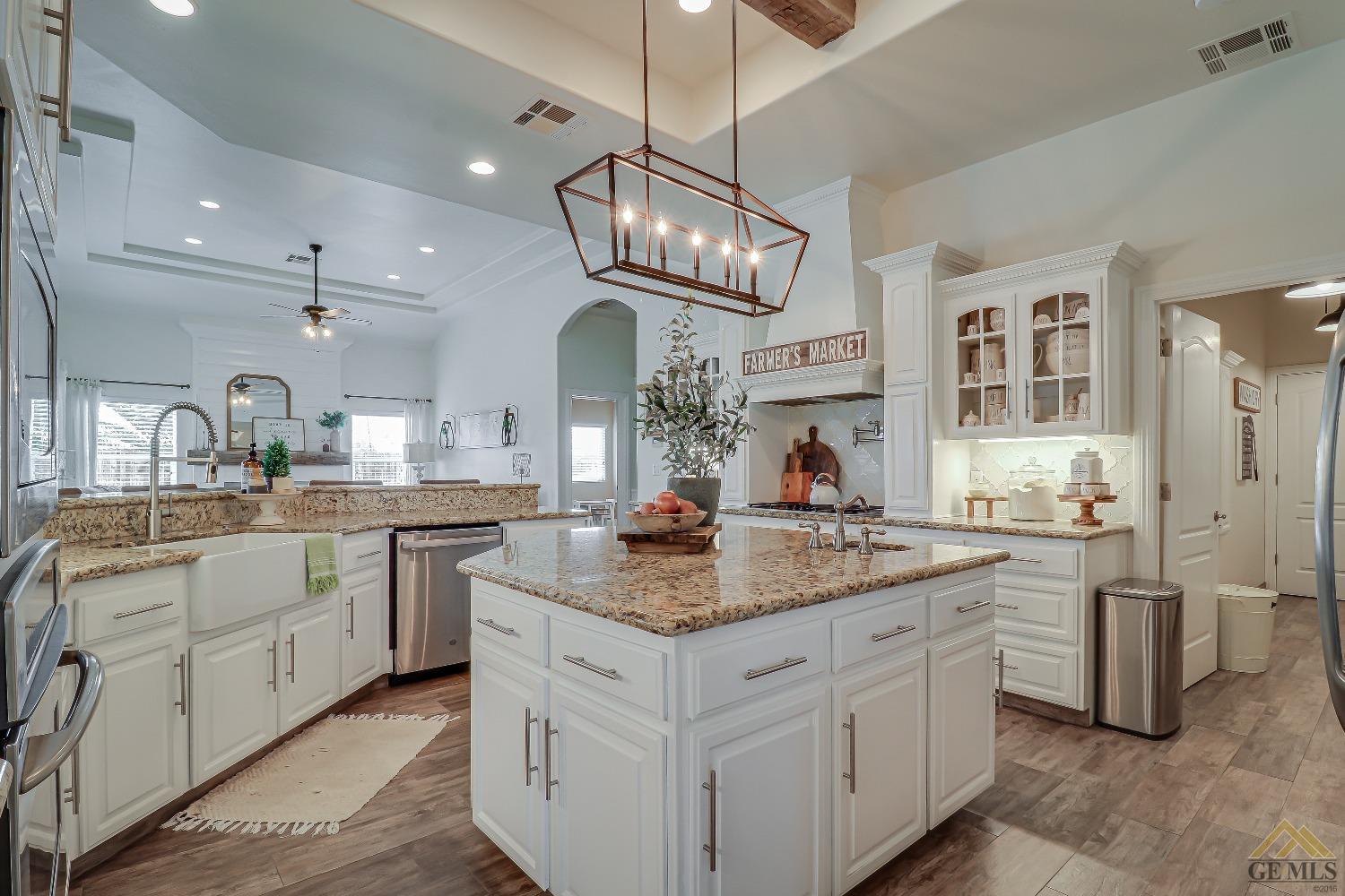 Undisclosed Address Bakersfield, CA 93314 - Photo 12 of 30 a kitchen with stainless steel appliances granite countertop a stove oven a sink dishwasher and white cabinets with wooden floor