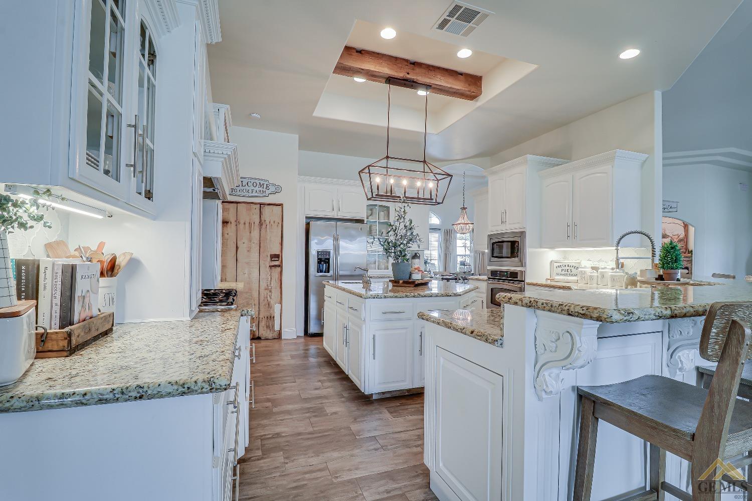 Undisclosed Address Bakersfield, CA 93314 - Photo 10 of 30 a kitchen with stainless steel appliances granite countertop a sink a stove and a wooden floors