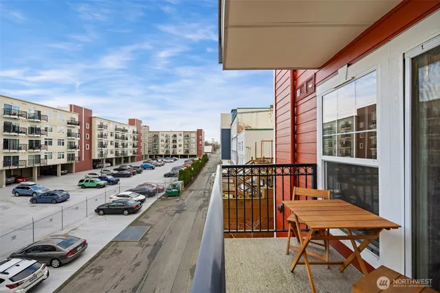 a balcony with wooden floor table and chairs