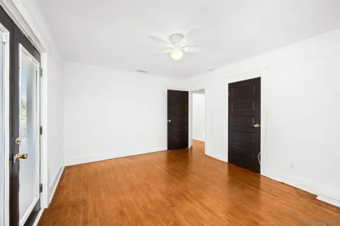 a view of an empty room with wooden floor