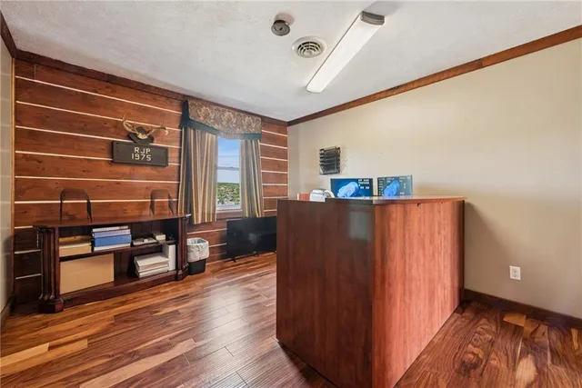 a view of a room with wooden floor and furniture