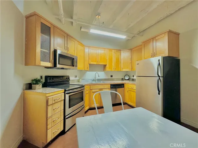 a kitchen with stainless steel appliances granite countertop a refrigerator stove microwave and sink