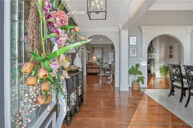 a hallway with painting on the wall and a potted plant