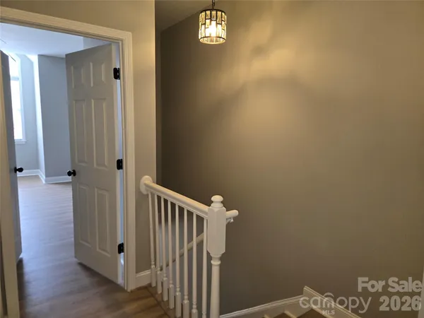a view of a hallway with wooden floor and a small space
