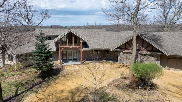 a view of a house with pool and trees in the background