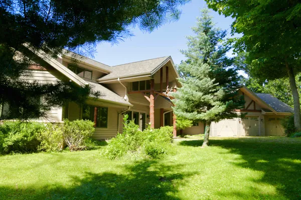 a view of a big house with a big yard and large trees