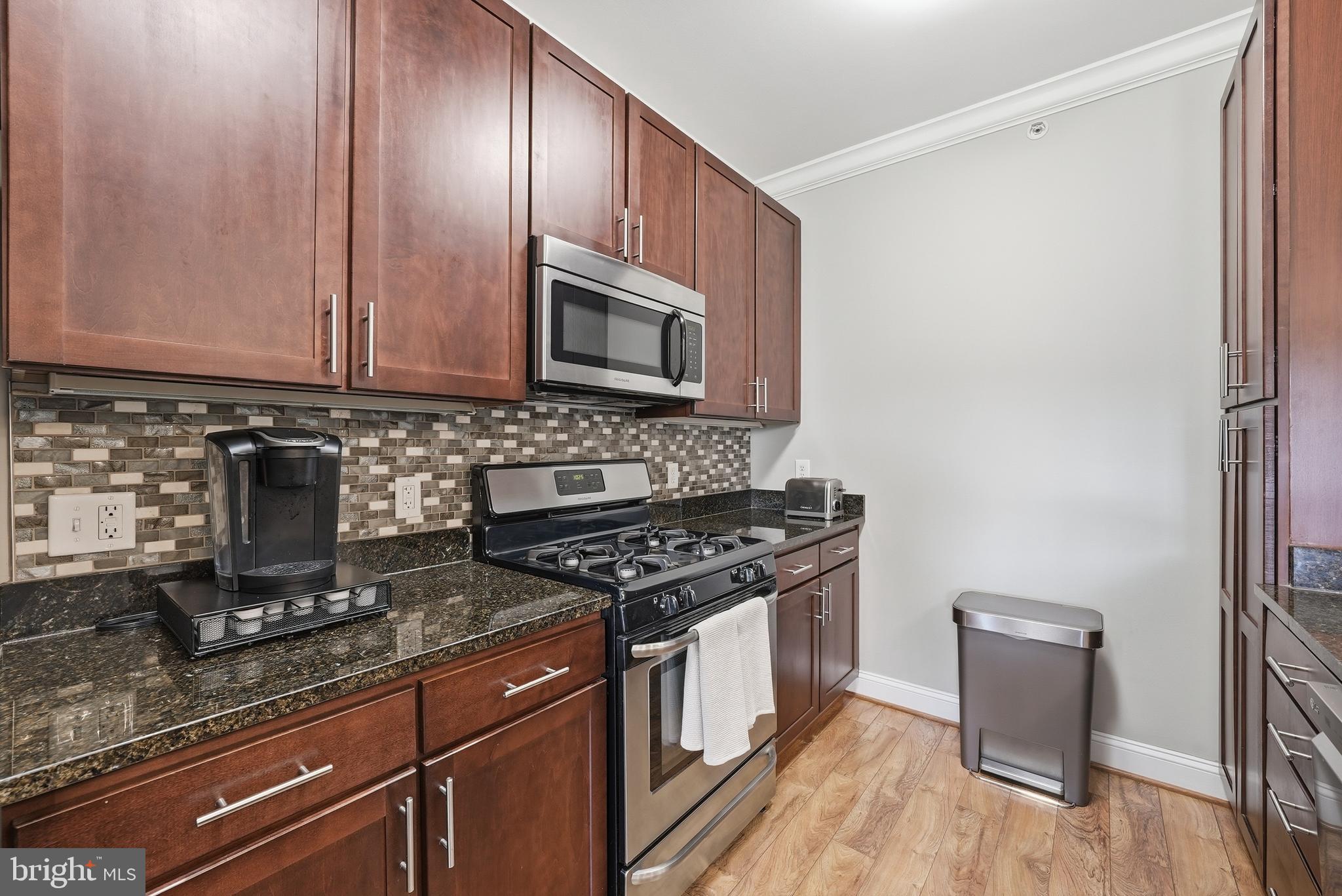 6301 Edsall Road, Unit 519 Alexandria, VA 22312 - Photo 6 of 33 a kitchen with granite countertop wooden cabinets and a stove top oven