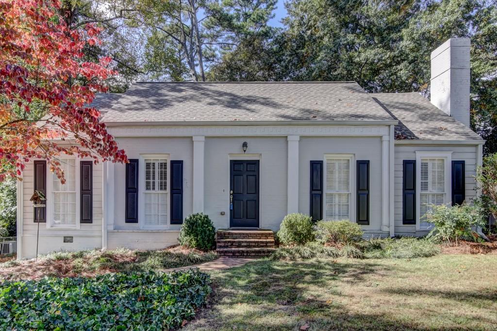 a view of a house with potted plants and a table and chairs